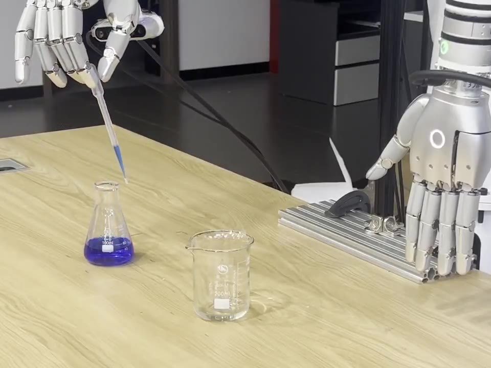 A five-finger robotic hand lifting a pipette out of a flask of blue liquid on a laboratory bench